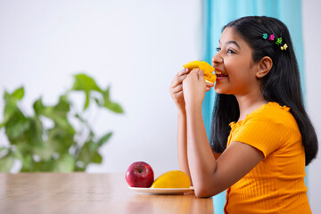 Portrait of cheerful girl holding a segmented slice of mango