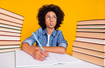 Portrait of attractive creative clever minded girl writing essay task subject pout lips isolated over bright yellow color background - obrazy, fototapety, plakaty