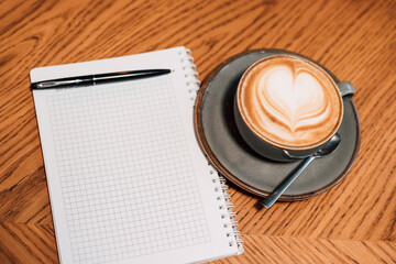 A cup of cappuccino coffee is on the table in a cafe