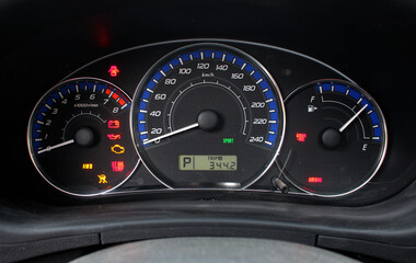 A close-up of a car panel with a speedometer indicating, oil and gasoline levels. Car panel, digital bright speedometer, odometer and other tools.
