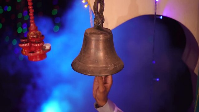 Hindu Temple Ringer Bell Closeup | Brass made bell is being rang by a person in blue background | Indian religious background
