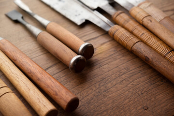 Woodworking chisels and saws on a old work table. Well used Japanese Ryoba saws and Dozuki saws on...