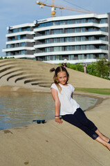 Fototapeta premium Happy family lifestyle and holiday concept. little girl walking, playing in fountain in city, street. laughing on a summer sunny day. Having fun. Staying cool