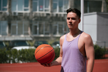 young guy plays basketball on the basketball court. throws the ball into the ring. doing sports. healthy body and healthy lifestyle