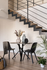 Dining table with two chairs next to stairs