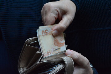 woman hand putting money in wallet, Turkish money in wallet
