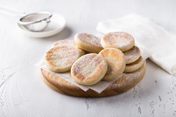 Wooden board with simple delicious homemade cookies baked in a pan on a light background