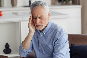 Exhausted mature aged man suffering from headache