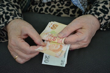 Turkish money, counting senior woman, holding hand.