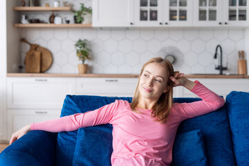 Smiling woman sitting on couch in cozy room