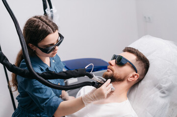 Laser depilation of beard contour. The depilation master treats the neck of a man with a laser.