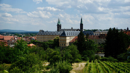 Blick vom Michelsberg auf das Kloster in Bamberg bei Sonnenschein mit kleinen Wolken