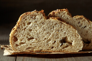 Brood, traditioneel zuurdesembrood in plakjes gesneden op een rustieke houten achtergrond. Concept van traditionele bakmethoden voor gezuurd brood. Gezond eten.