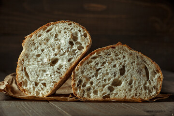 Bread, traditional sourdough bread cut into slices on a rustic wooden background. Concept of traditional leavened bread baking methods. Healthy food.