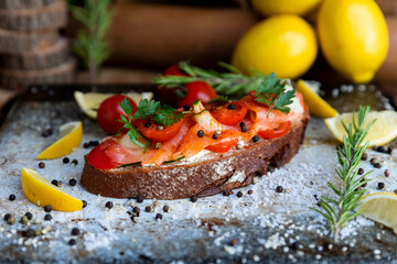 Salted salmon open sandwich with tomatoes, cream cheese, cucumber, parsley and pepper. Healthy seafood