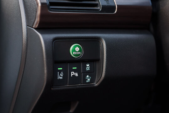 Green eco mode drive button in a modern car. Economic mode button, lane keep assist, parking assist, and electronic stability program (esp) button inside the car. Green ECON button on a dashboard.