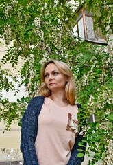 Beautiful middle-aged woman, in the spring on a background of blooming acacia.