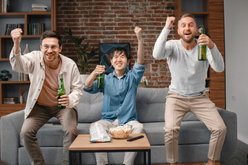 Front view of men watching a football game on tv and drinking a beer