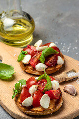 Open sandwiches with cherry tomatoes, mini mozzarella, fresh basil leaves, caprese on bread, Traditional italian appetizer or snack, antipasto. banner, menu, recipe place for text, top view
