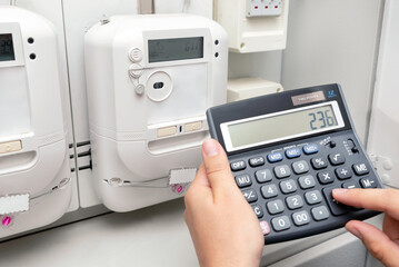 Man with calculator and energy electric meter