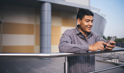 Asian millennial guy using mobile phone outdoor