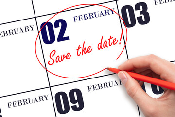 Hand drawing red line and writing the text Save the date on calendar date February 2.