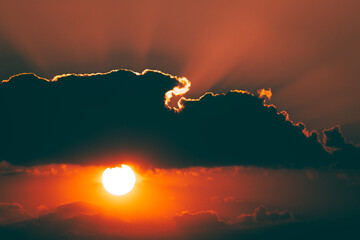 Sun behind a dark cloud