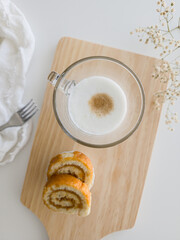 Latte macchiato coffee and swiss roll, roll cake over white background