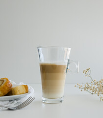 Latte macchiato coffee and swiss roll, roll cake over white background