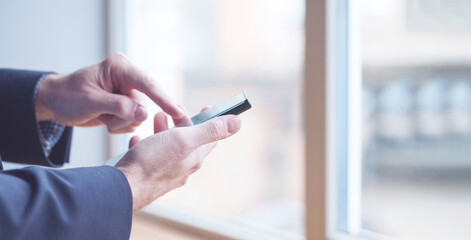 Closeup photo of male hands with smartphone in day light
