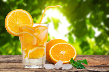 Natural lemonade with mint and fresh oranges on wooden table.