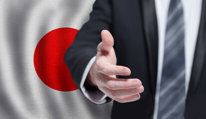 Japanese business, politics, cooperation and travel concept. Hand on flag of Japan background.