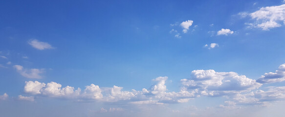 Sunny day background with blue sky and clouds.