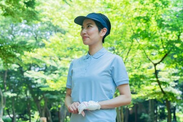 遠く見つめるゴルフウェアを着た日本人女性