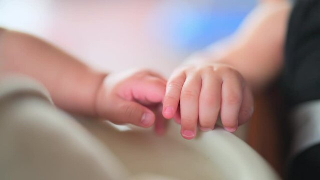 Close Up View Of Twin Newborn Hands Holding Together. Twin Infant Hands Holding.