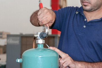 professional electrician with air-condition gas cylinder on the rooftop