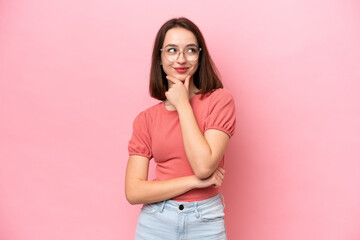 Young Ukrainian woman isolated on pink background thinking an idea while looking up