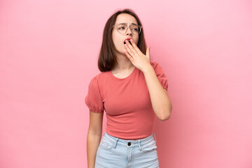 Young Ukrainian woman isolated on pink background yawning and covering wide open mouth with hand