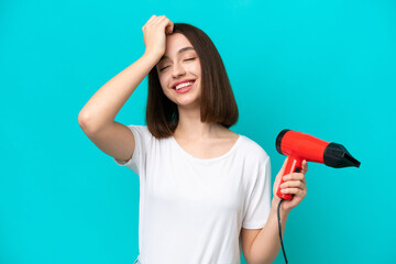 Young Ukrainian holding a hairdryer isolated on blue background has realized something and intending the solution