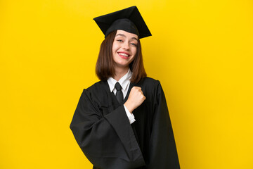 Young university graduate Ukrainian woman isolated on yellow background celebrating a victory