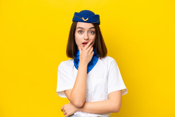 Airplane stewardess Ukrainian woman isolated on yellow background surprised and shocked while looking right