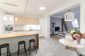 Modern apartment kitchen with a counter and three bar stools