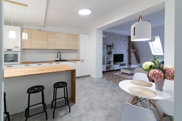 Modern apartment kitchen with a counter and three bar stools
