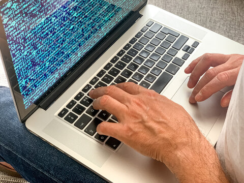 Man sitting on sofa before going to office using laptop making report checking business index home. IT specialist, code developer, python, coder