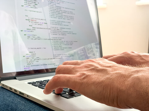 Man sitting on sofa before going to office using laptop making report checking business index home. IT specialist, code developer, python, coder