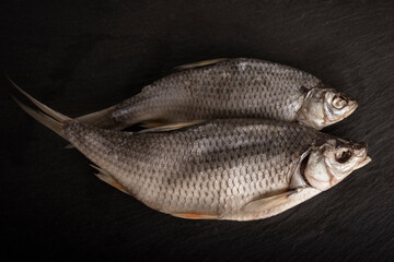 Close-up of dried fish on a black table background. Salty snack for beer. top view