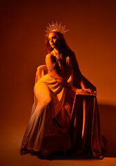 Full length portrait of beautiful red head woman wearing long flowing fantasy toga gown with golden...