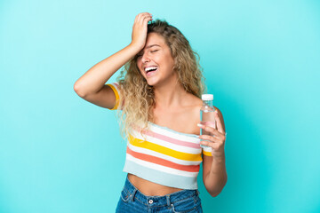 Young blonde woman with a bottle of water isolated on blue background has realized something and intending the solution