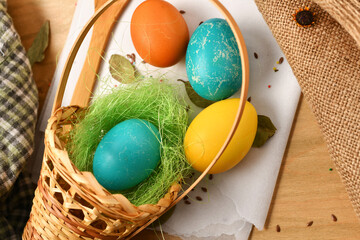 easter eggs in a nest of grass in a basket, wooden background, holiday still life and decorations