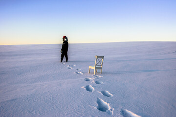 person walking on the snow field and white chair  - Powered by Adobe